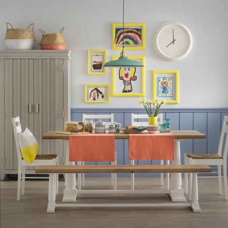 Vit matsal med pulverblå panel och bord med bänk