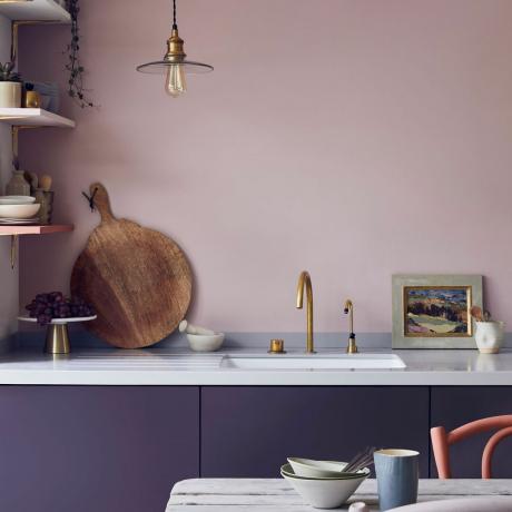 보라색으로 칠해진 캐비닛이 있는 분홍색 주방