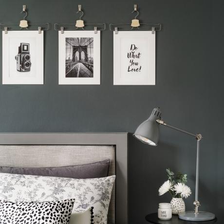חדר שינה עם קירות אפורים ומתלי מעילים אומנות תלויה