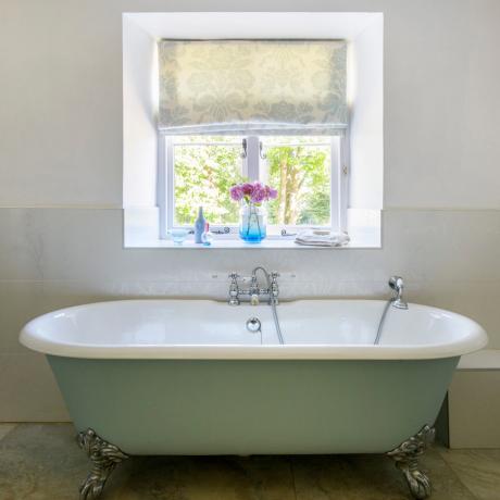 Landhaus-Badezimmer mit mintfarbener Rolltop-Badewanne