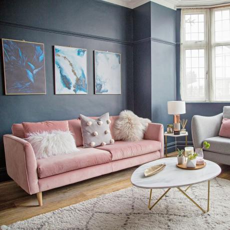 Tmavě šedé stěny obývacího pokoje s růžovou pohovkou