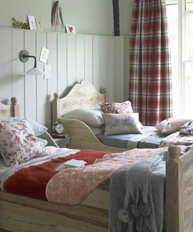 Mysigt sovrum med två enkelsängar och tartan-gardiner