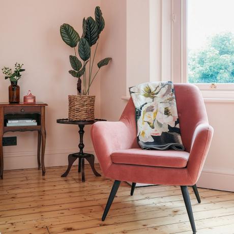 Pink lejlighedsvis stol ved vindue i lyserødt malet soveværelse