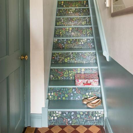 duvar kağıdıyla kaplanmış yükselticilere sahip gri boyalı merdiven