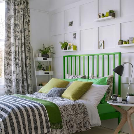 חדר שינה עם קירות לבנים ומיטה ירוקה