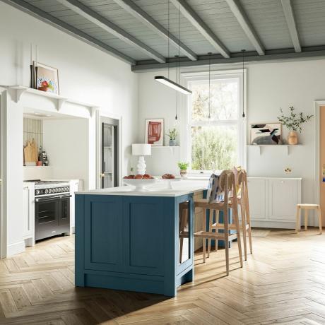 Avatud planeeringuga köök sinise köögisaare ja puidust taburettidega.