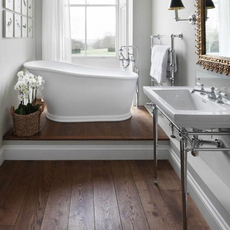 Dřevěná podlaha v koupelně s volně stojící bílou vanou