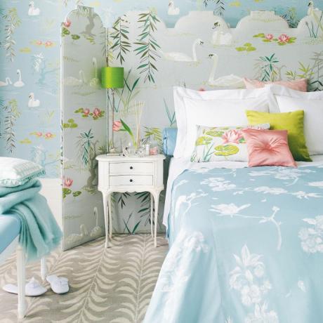 Aqua ja kahvatusinise lilleline magamistuba kahe tooniga vaibaga, voodi taga sirm, laimirohelised aktsendid