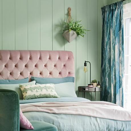 Soverom med grønne vegger og rosa sengegavl