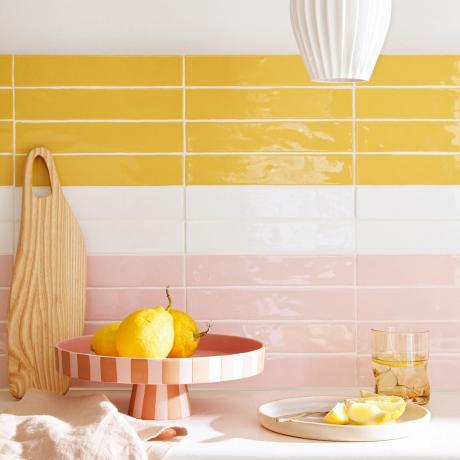 Cozinha com splashback de azulejos metro amarelo, branco e rosa