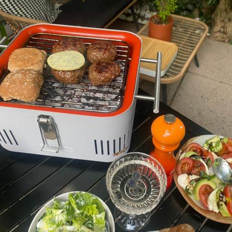 Le Cube BBQ en action avec burgers et buns en cuisson, salades en accompagnement