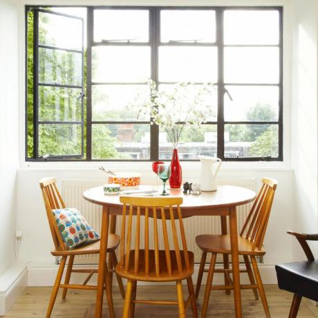 หน้าต่าง Crittall ดั้งเดิมในบ้านลอนดอนศตวรรษที่ 20 โต๊ะและเก้าอี้ไม้ด้านหน้าหน้าต่าง