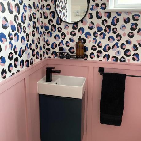 lavabo ve siyah musluk ve hayvan desenli duvar kağıdı ile alt katta tuvalet