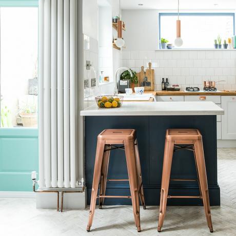 Mėlyna virtuvės pusryčių juosta su koloniniu radiatoriumi ir varinėmis baro kėdėmis