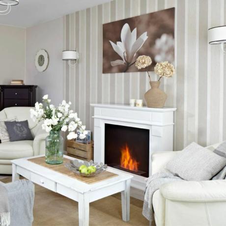暖炉と花のアートと白いコーヒー テーブルのある白いリビング ルーム