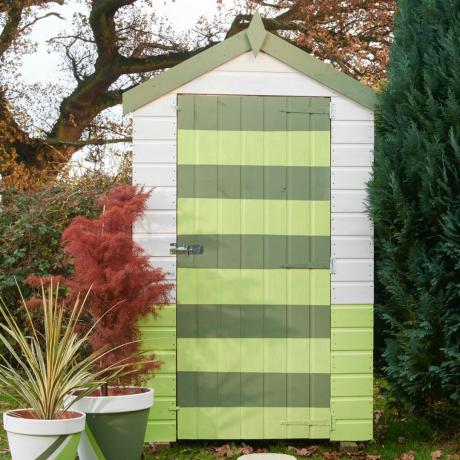 緑のストライプで塗装された庭の小屋