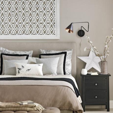 Chambre à coucher avec des oeuvres d'art en treillis blanc au-dessus du lit