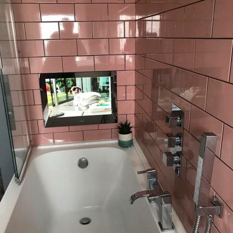 Telewizor w łazience z różowymi płytkami ściennymi