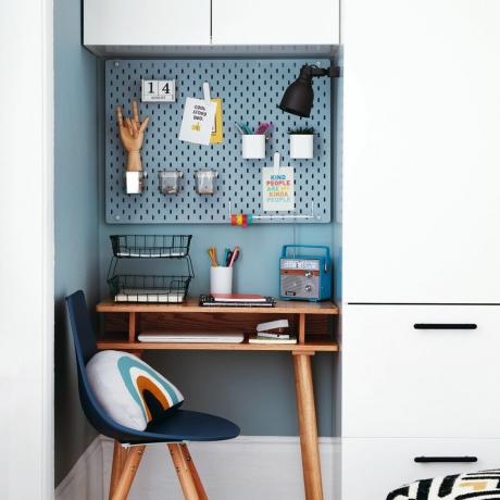 Blå opslagstavle mod blåmalet væg i soveværelses skrivebordsalkove