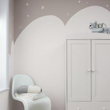 Diseño pintado con nubes en gris y blanco en las paredes, detrás de la silla blanca y el armario