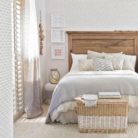 Dormitor luminos, cu tapet neutru de coastă și pat din lemn