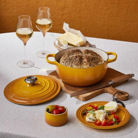 ყვითელი თუჯის ქოთანი და სადილის ჭურჭელი მაგიდაზე