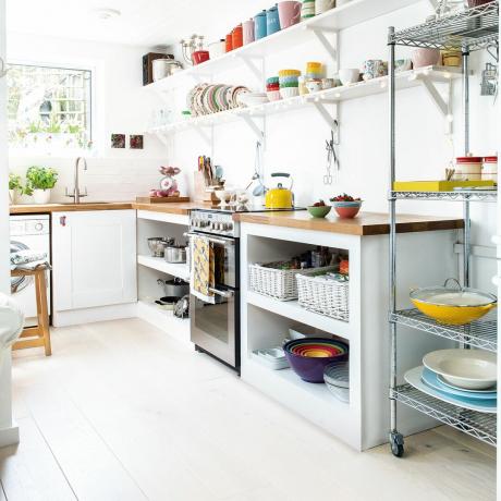 Balta virtuvė su dažytomis grindimis ir atviromis lentynomis