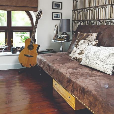 Тамно браон антилоп софа у дневној соби са гитаром