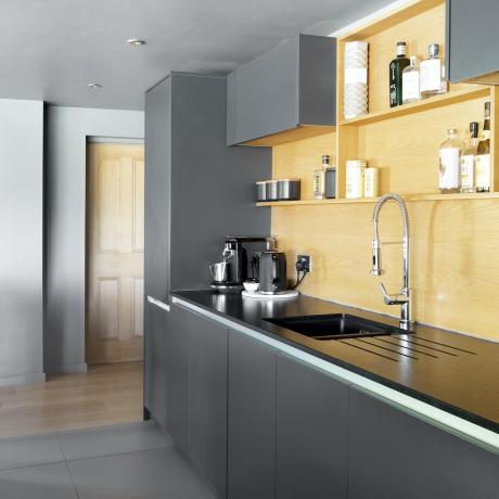 黒の複合ワークトップを備えた現代的な灰色のキッチンエクステンション