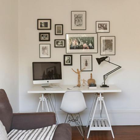 sala de estar blanca moderna con escritorio y obras de arte