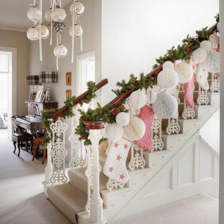lorong-lorong tradisional dihiasi untuk Natal dengan karangan bunga, stoking, dan pernak-pernik kertas