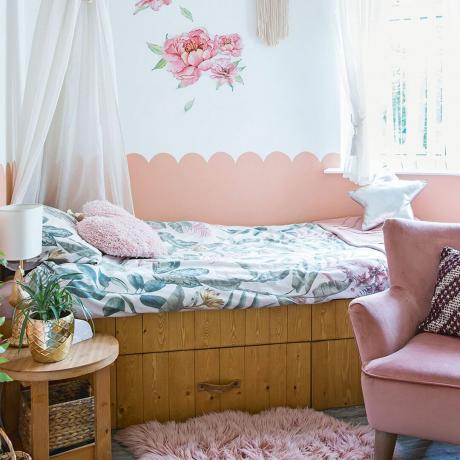 спалня за момичета с боядисана в розово миди стена и балдахин на леглото