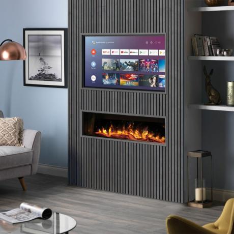 평면 와이드스크린 TV와 전기 화재가 있는 회색 벽