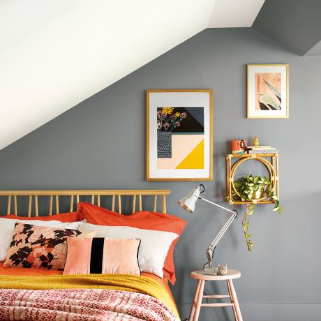Šedá spálňa s drevenou posteľou akcentovanými farbami horčice a oranžovej