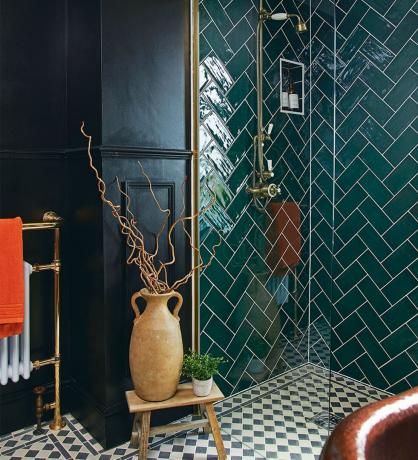 Kopalnica z zadnjimi stenami, enobarvnimi talnimi ploščicami in zelenimi stenskimi ploščicami za prho