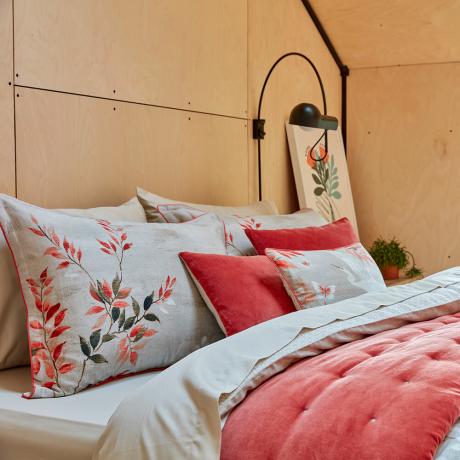 namuose sukurkite prabangų viešbučio miegamąjį su lova, padengta pagalvėmis ir pagalvėmis