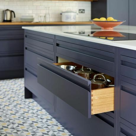 Cozinha azul com gaveta de cozinha contendo panelas
