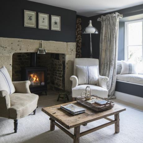 kényelmes nappali nagy kő kandallóval és feketére festett falakkal