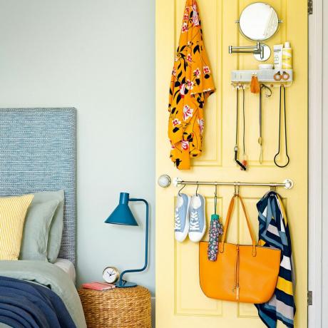 מקרוב של דלת חדר שינה צהובה עם ווים ומתלים