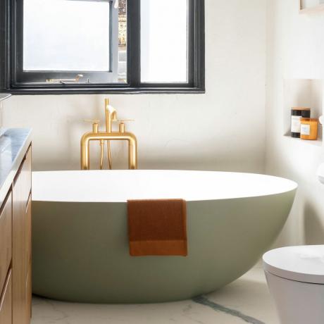 зелена свободностояща вана в модерна баня