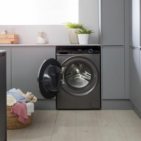 Donkergrijze wasmachine met open deur in wasruimte