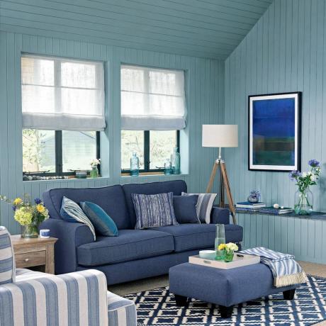 Blye stue med vægpaneler og matchende sofa og skammel