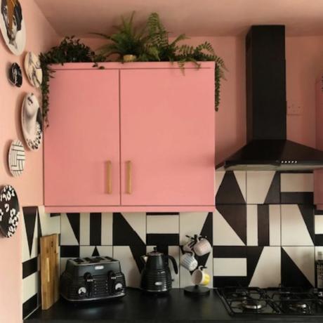 სამზარეულო ვარდისფერი კედლის კარადით და გრაფიკული მონოქრომული ფილებით