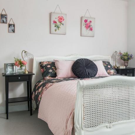 Harmaa makuuhuone, jossa vaaleanpunaisia ​​kukkakuvia sängyn yläpuolella
