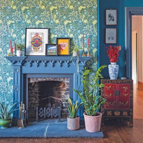 Obývací pokoj s modrým tapetovaným komínem, modrými stěnami a modrým krbem.