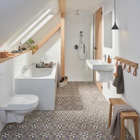 Geometrické koupelnové dlaždice v bílé koupelně se šikmým stropem