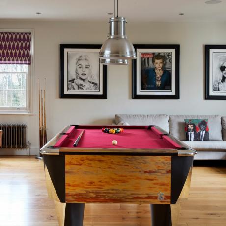 חדר משחקים פאנקי עם שולחן ביליארד מואר ואמנות קיר איקונית