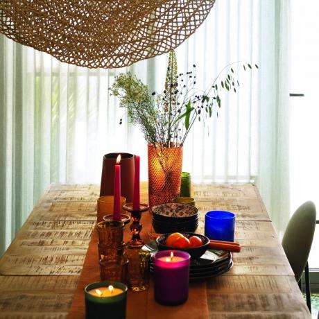 postavitev jedilne mize z barvno steklovino in posodo ter nizko visečo lučjo