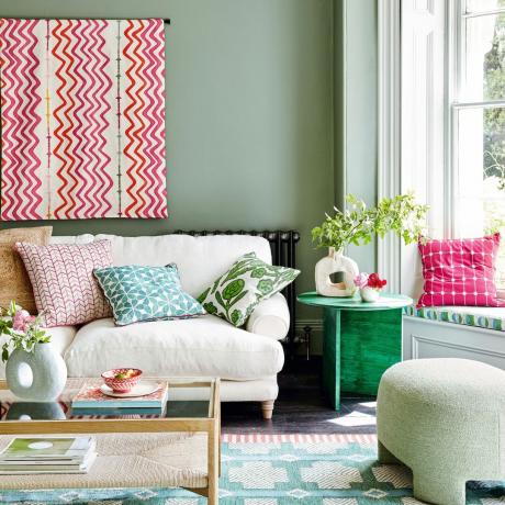 Dzīvojamā istaba ar rakstainu un krāsainu dekoru, dīvānu un kafijas galdiņu