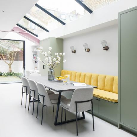 Moderný jedálenský kút so sivými jedálenskými stoličkami a kanárikovo žltým banketovým posedením